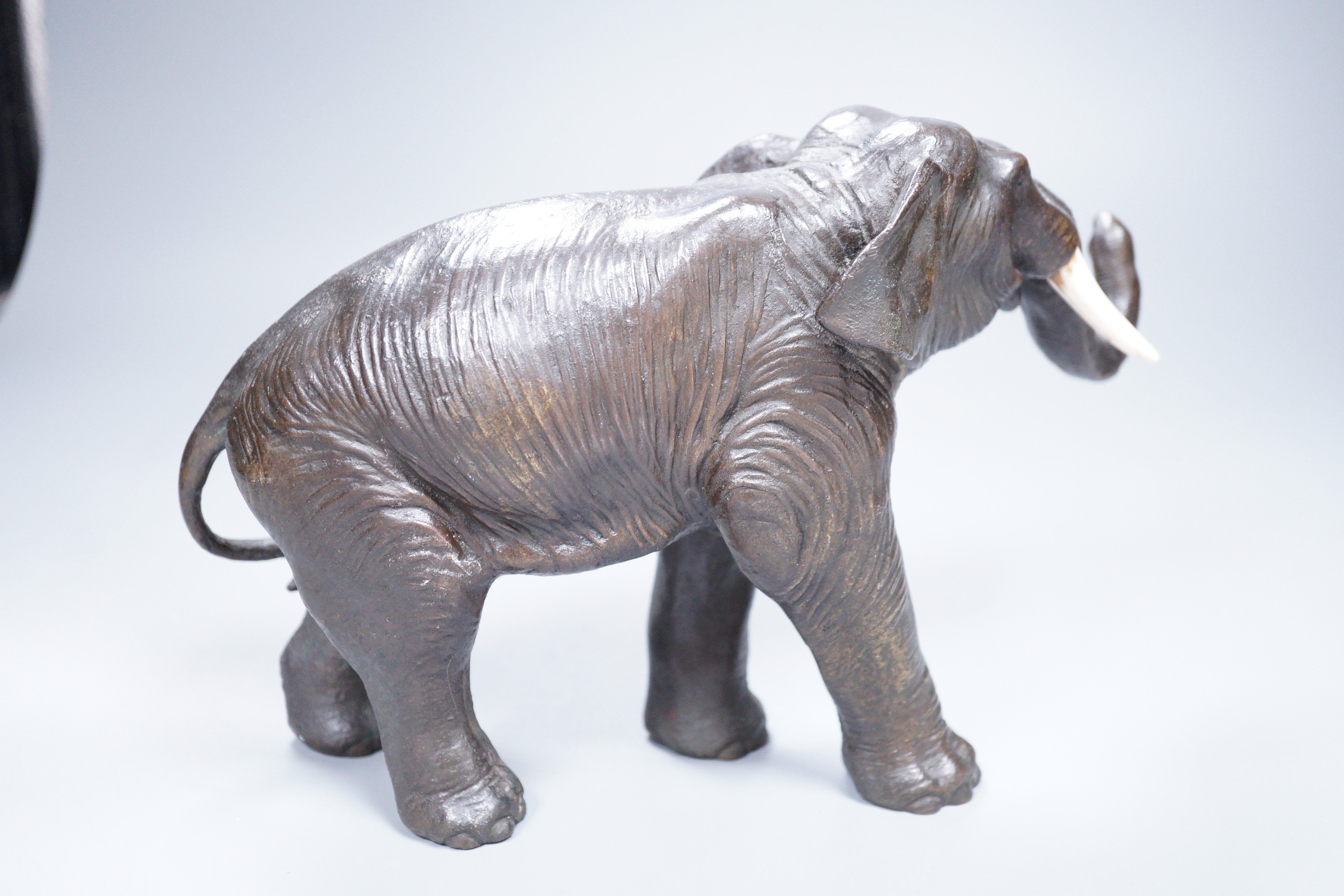 A Japanese Meiji period cast bronze model of an elephant, with ivory tusks, 17cm tall